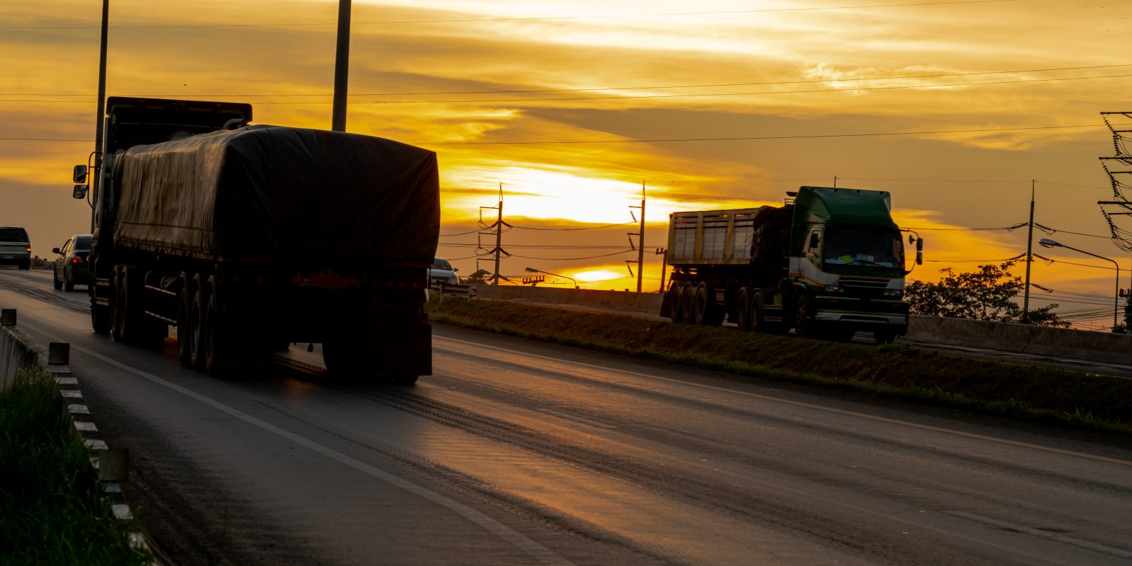 Truck with Cargo driving on road transportation highway at sunset in summer