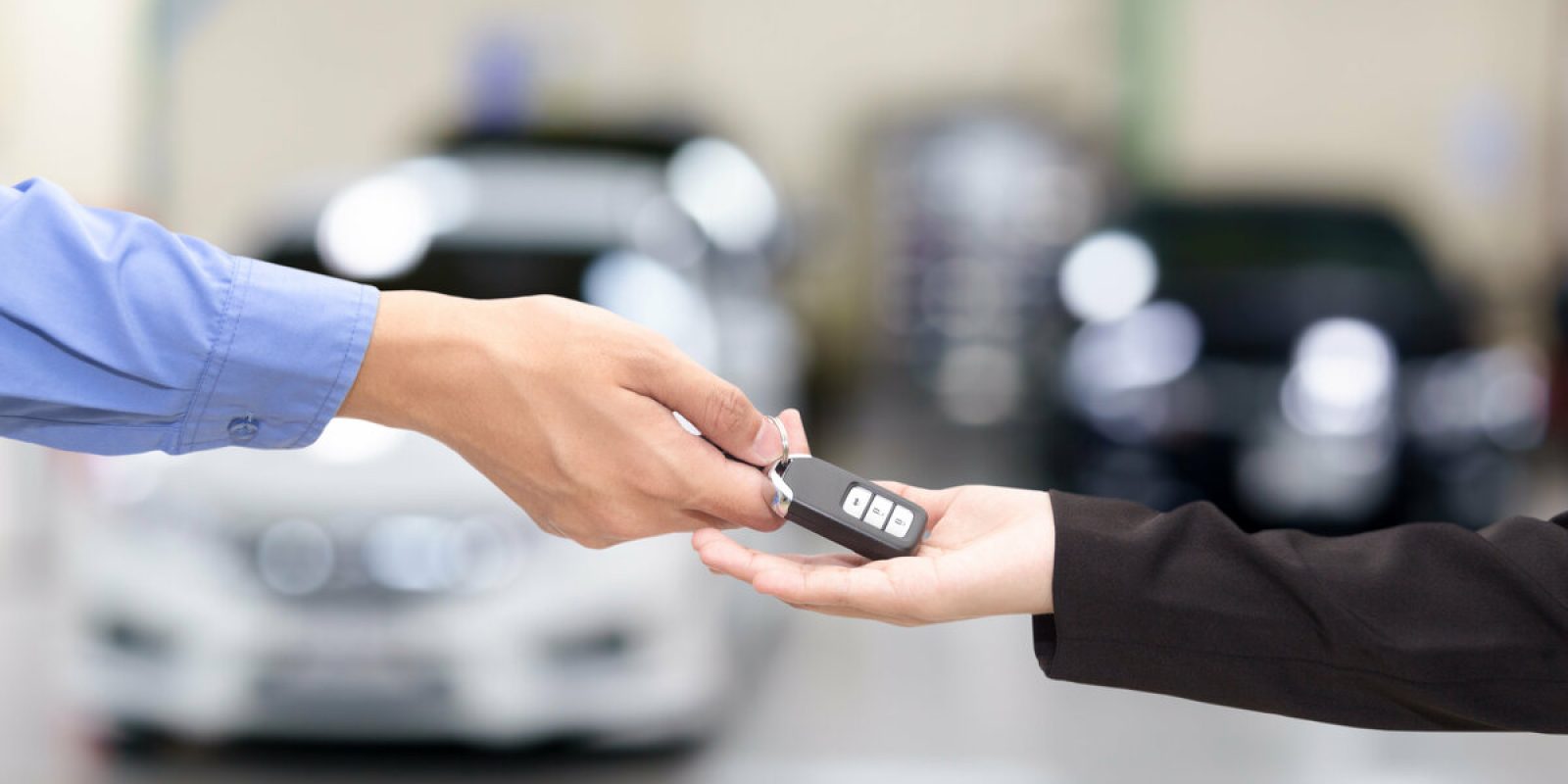 Young business women giving a key car in font of car